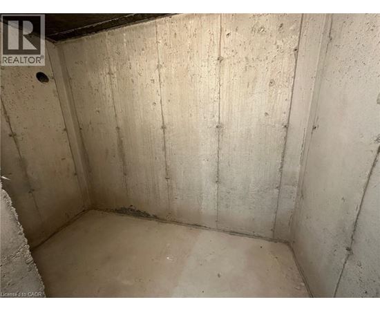 A dirty, unfinished basement with concrete walls and floor.