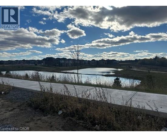 A realtor's photo of a landscape with a body of water and houses in the distance.