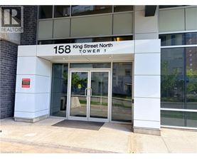 The entrance to a building with a glass door and a sign that reads "158 King Street North Tower 1".