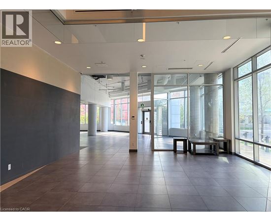 A large, empty room with a REALTOR® logo on the wall.