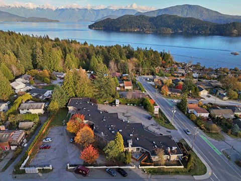 A small town with a lake and mountains in the background.