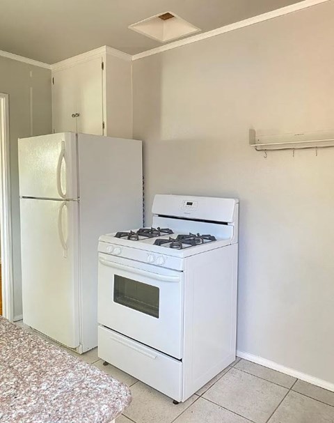 A white stove and refrigerator in a kitchen.