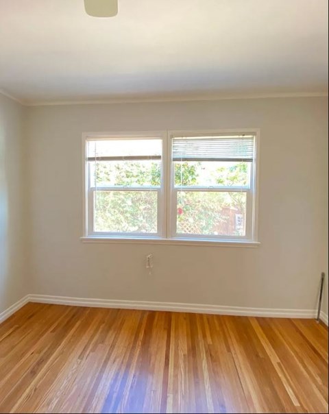 A room with a window and wooden floors.