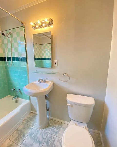 A white toilet sits next to a sink in a bathroom.