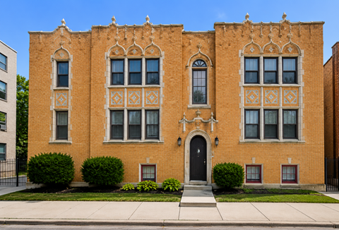 A red brick building with a black door and windows.