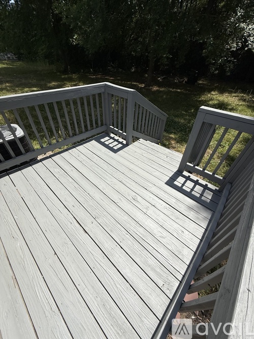 A wooden deck with a railing and a table.