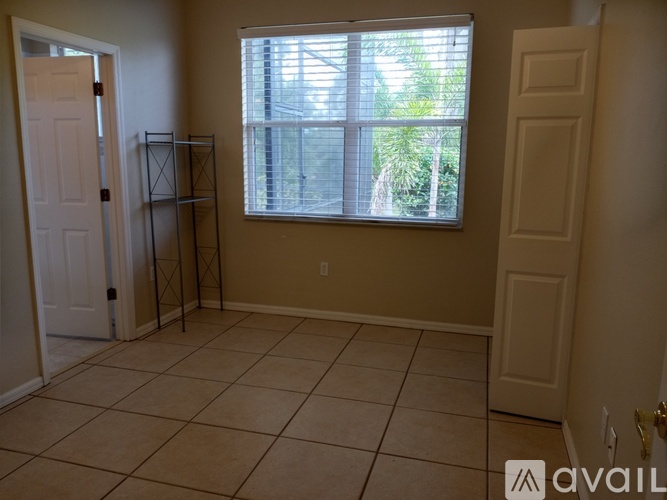 A room with a tiled floor and a window with blinds.