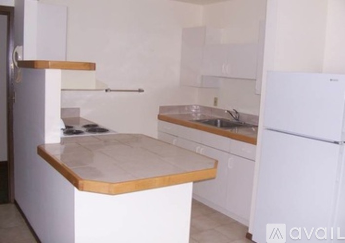 A kitchen with white cabinets and a white fridge.