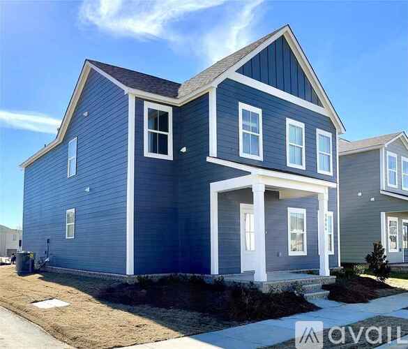 A blue house with white trim and a white garage door.