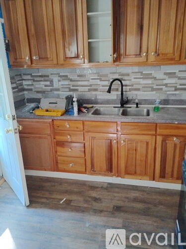 A kitchen with wooden cabinets and a stone backsplash.
