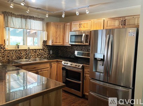 A kitchen with wooden cabinets and stainless steel appliances.