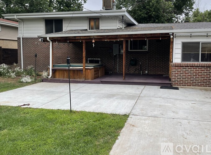 A backyard with a hot tub and a covered patio area.
