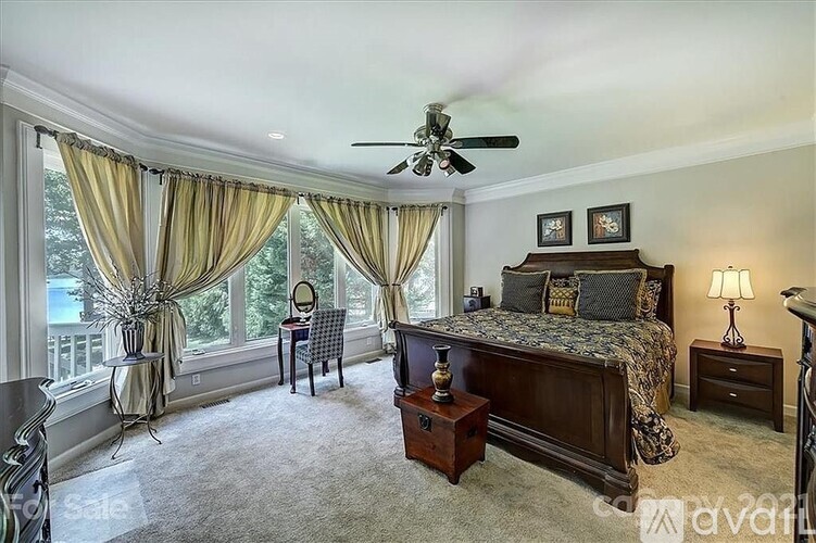 A bedroom with a large bed and a desk with a chair.
