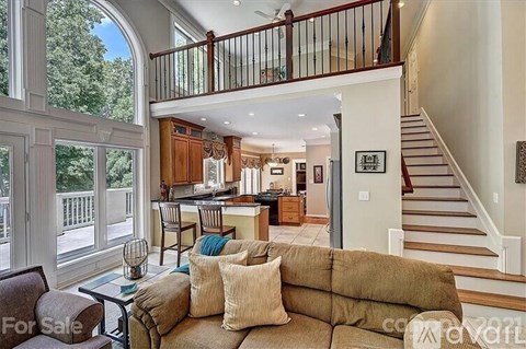 A living room with a couch and a table in front of a staircase.