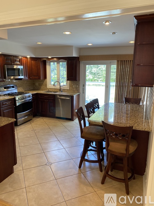 A kitchen with brown cabinets and a granite countertop.
