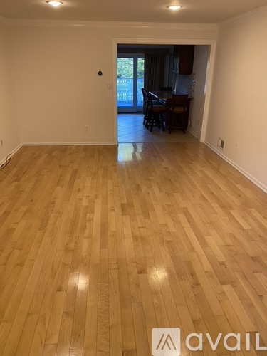 A room with wooden flooring and a door leading to a balcony.