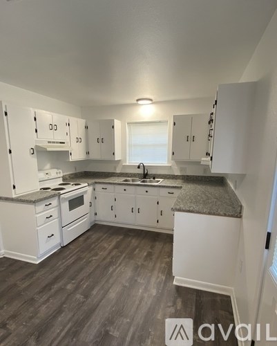 A kitchen with white appliances and cabinets.