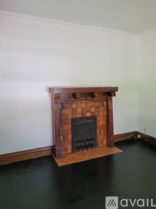 A fireplace with a wooden mantle and tile surround.