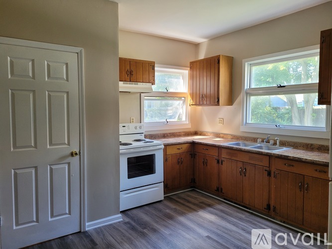 A kitchen with wooden cabinets and a white stove top oven.