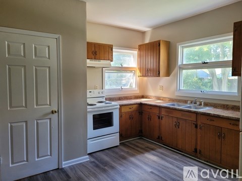 A kitchen with wooden cabinets and a white stove top oven.