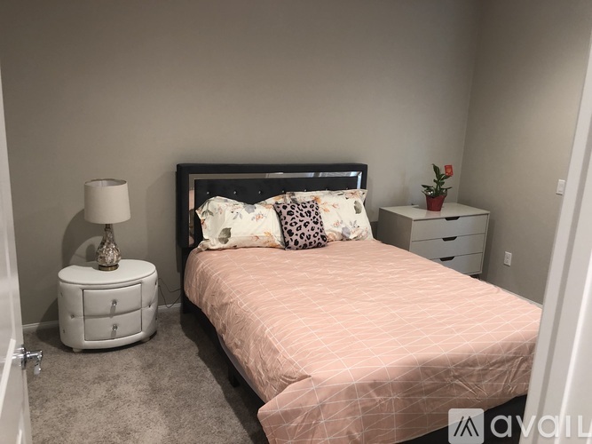 A bedroom with a bed, nightstand, and lamp.