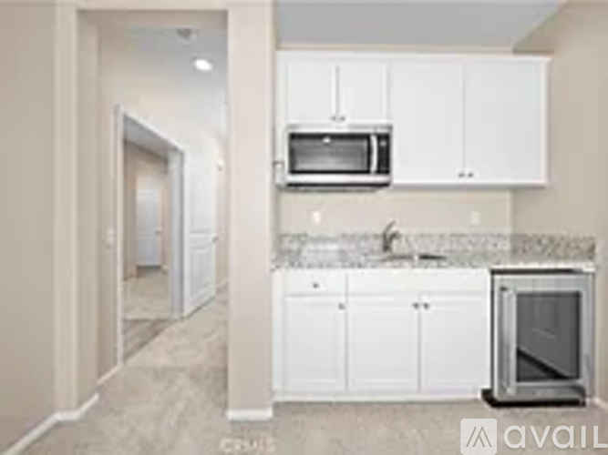 A kitchen with white cabinets and a microwave above the stove.