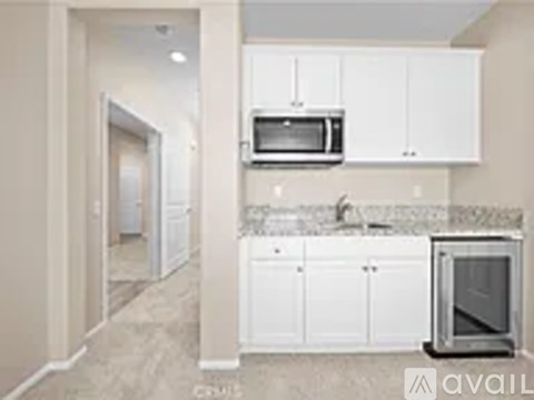 A kitchen with white cabinets and a microwave above the stove.