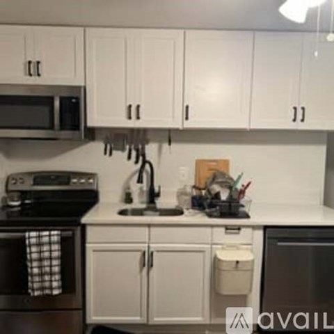 A kitchen with white cabinets and a black stove top.