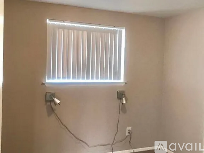 A window with blinds and two wall-mounted lights.