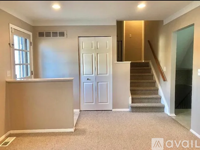 A spacious room with a staircase leading to the upper floor.