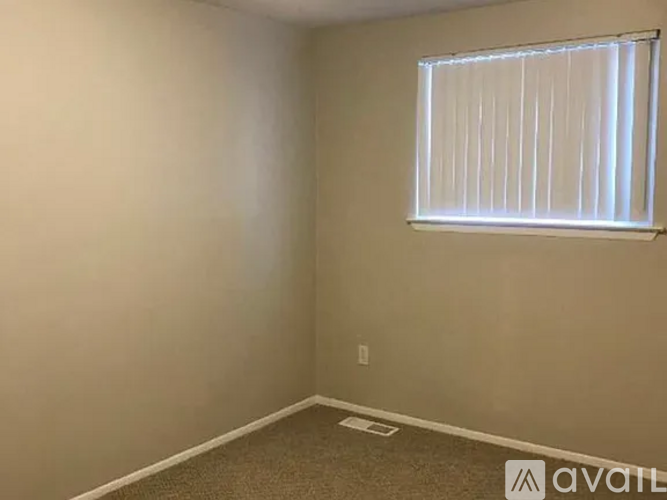 A room with a window and carpeted floor.