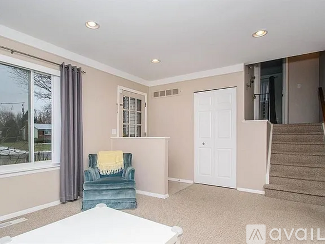 A living room with a blue chair and a white couch.