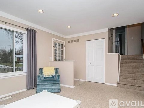 A living room with a blue chair and a white couch.