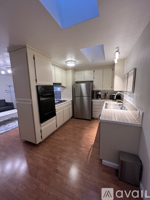 A kitchen with wooden floors and a skylight.