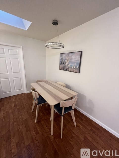 A dining room with a wooden table and chairs.