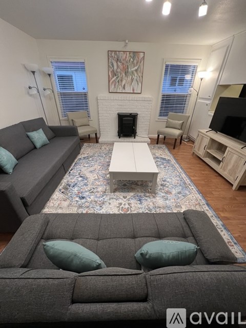 A living room with a grey couch and a white coffee table.