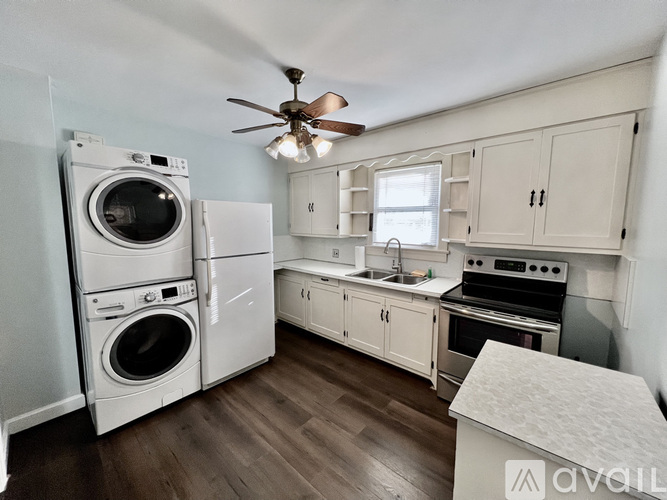 A laundry room with a washer and dryer, a sink, and a stove.