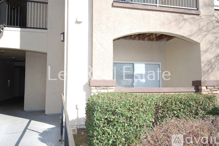 A building with a balcony and a window with a sign that says "Le Eslade".