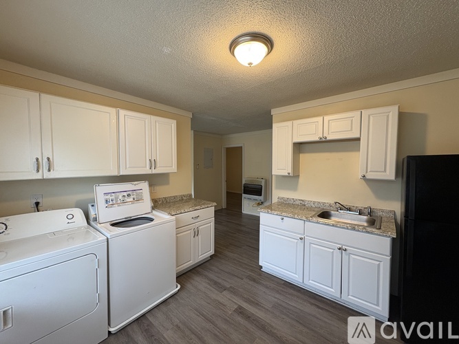 A kitchen with white appliances and cabinets.