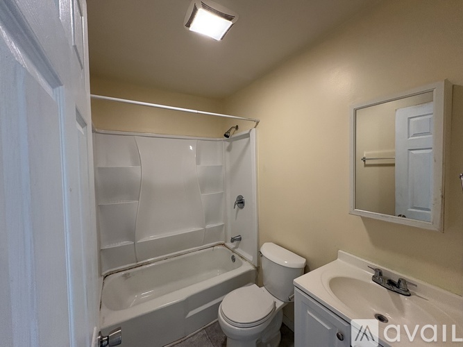 A bathroom with a toilet, sink, and bathtub.