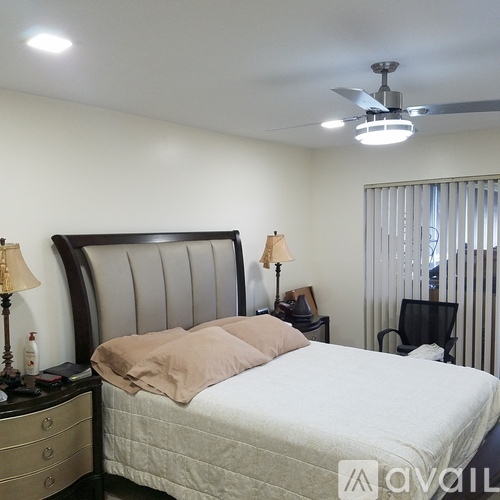 A bedroom with a large bed and a ceiling fan.