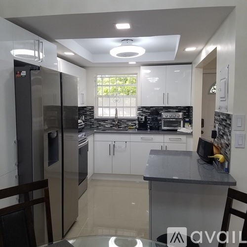 A kitchen with a black counter top and white cabinets.