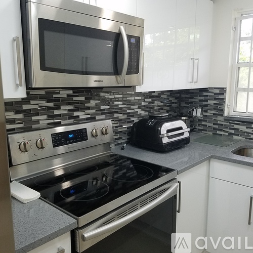 A modern kitchen with a stove, microwave, and toaster.