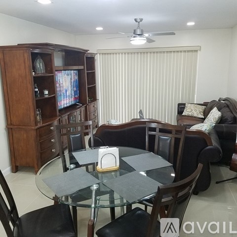 A living room with a glass table and a television.