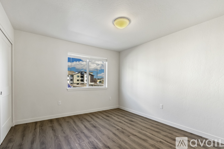 A room with a window showing a building outside.