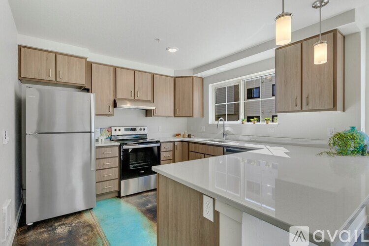 A kitchen with a refrigerator, oven, and sink.