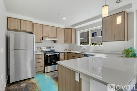A kitchen with a refrigerator, oven, and sink.
