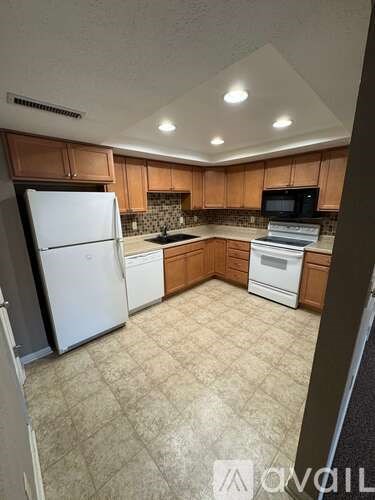 A kitchen with a white refrigerator and a white dishwasher.