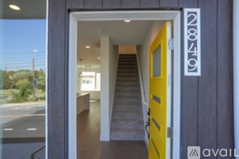 A yellow door with a sign that says "avail" on the side of a building.