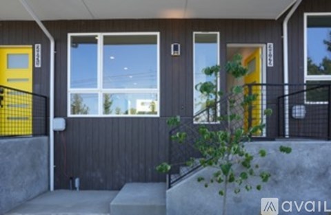 A house with a yellow door and a black railing.